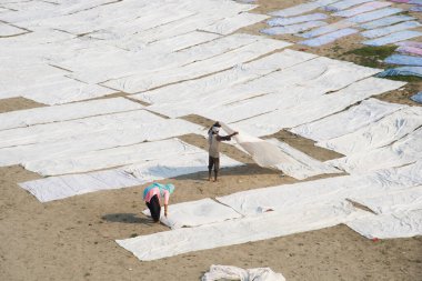 Agra, Hindistan - 15 Şubat 2018: Kimliği belirsiz insanlar Yanuma Agra nehrinin kıyısında sıcak güneşte yıkandıktan sonra bez kurutuyorlar 