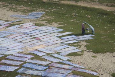 Agra, Hindistan - 15 Şubat 2018: Kimliği belirsiz insanlar Yanuma Agra nehrinin kıyısında sıcak güneşte yıkandıktan sonra bez kurutuyorlar 