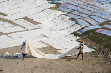 Agra, Hindistan - 15 Şubat 2018: Kimliği belirsiz insanlar Yanuma Agra nehrinin kıyısında sıcak güneşte yıkandıktan sonra bez kurutuyorlar 