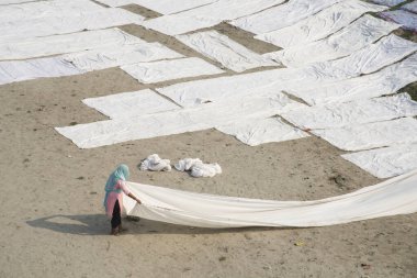 Agra, Hindistan - 15 Şubat 2018: Kimliği belirsiz insanlar Yanuma Agra nehrinin kıyısında sıcak güneşte yıkandıktan sonra bez kurutuyorlar 