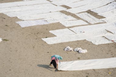 Agra, Hindistan - 15 Şubat 2018: Kimliği belirsiz insanlar Yanuma Agra nehrinin kıyısında sıcak güneşte yıkandıktan sonra bez kurutuyorlar 