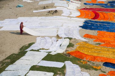 Agra, Hindistan - 15 Şubat 2018: Kimliği belirsiz insanlar Yanuma Agra nehrinin kıyısında sıcak güneşte yıkandıktan sonra bez kurutuyorlar 