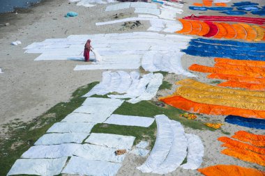 Agra, Hindistan - 15 Şubat 2018: Kimliği belirsiz insanlar Yanuma Agra nehrinin kıyısında sıcak güneşte yıkandıktan sonra bez kurutuyorlar 