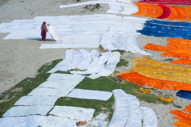 Agra, Hindistan - 15 Şubat 2018: Kimliği belirsiz insanlar Yanuma Agra nehrinin kıyısında sıcak güneşte yıkandıktan sonra bez kurutuyorlar 