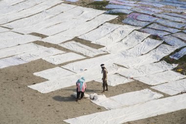 Agra, Hindistan - 15 Şubat 2018: Kimliği belirsiz insanlar Yanuma Agra nehrinin kıyısında sıcak güneşte yıkandıktan sonra bez kurutuyorlar 