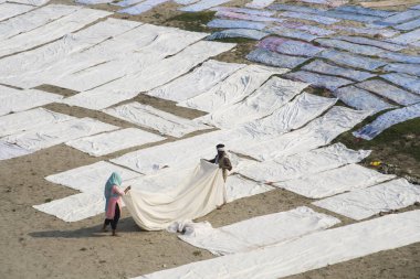 Agra, Hindistan - 15 Şubat 2018: Kimliği belirsiz insanlar Yanuma Agra nehrinin kıyısında sıcak güneşte yıkandıktan sonra bez kurutuyorlar 