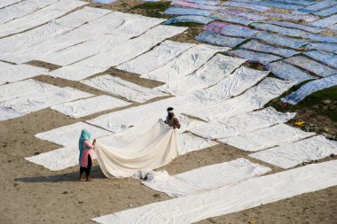 Agra, Hindistan - 15 Şubat 2018: Kimliği belirsiz insanlar Yanuma Agra nehrinin kıyısında sıcak güneşte yıkandıktan sonra bez kurutuyorlar 