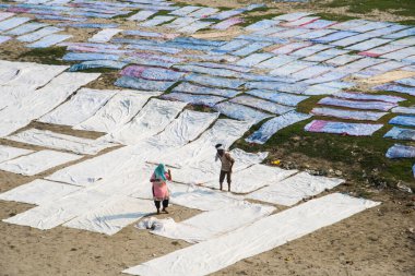 Agra, Hindistan - 15 Şubat 2018: Kimliği belirsiz insanlar Yanuma Agra nehrinin kıyısında sıcak güneşte yıkandıktan sonra bez kurutuyorlar 
