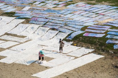 Agra, Hindistan - 15 Şubat 2018: Kimliği belirsiz insanlar Yanuma Agra nehrinin kıyısında sıcak güneşte yıkandıktan sonra bez kurutuyorlar 