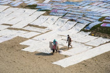 Agra, Hindistan - 15 Şubat 2018: Kimliği belirsiz insanlar Yanuma Agra nehrinin kıyısında sıcak güneşte yıkandıktan sonra bez kurutuyorlar 