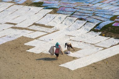 Agra, Hindistan - 15 Şubat 2018: Kimliği belirsiz insanlar Yanuma Agra nehrinin kıyısında sıcak güneşte yıkandıktan sonra bez kurutuyorlar 