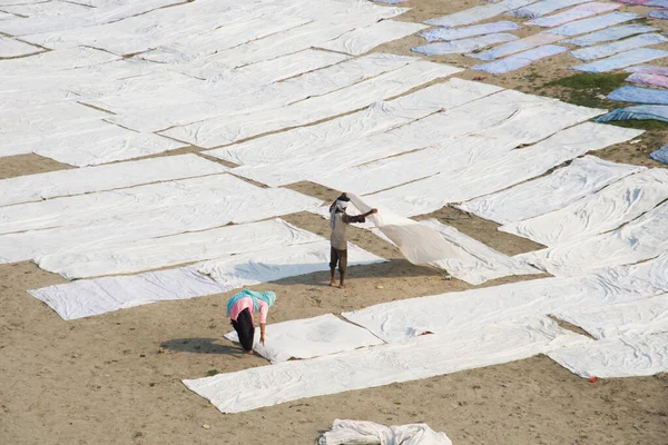 Agra, Hindistan - 15 Şubat 2018: Kimliği belirsiz insanlar Yanuma Agra nehrinin kıyısında sıcak güneşte yıkandıktan sonra bez kurutuyorlar 