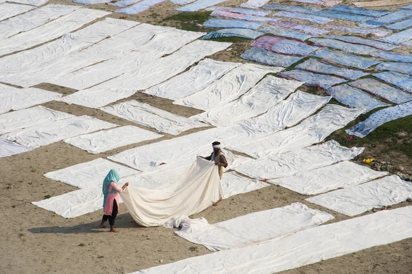 Agra, Hindistan - 15 Şubat 2018: Kimliği belirsiz insanlar Yanuma Agra nehrinin kıyısında sıcak güneşte yıkandıktan sonra bez kurutuyorlar 