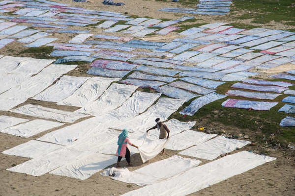 Agra, India - February 15, 2018: Unidentified people Drying cloth after washing in the hot sun on banks of River Yanuma Agra India 