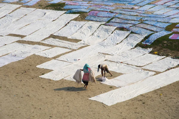 Agra, Hindistan - 15 Şubat 2018: Kimliği belirsiz insanlar Yanuma Agra nehrinin kıyısında sıcak güneşte yıkandıktan sonra bez kurutuyorlar 