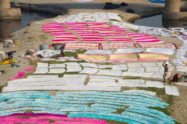 Agra, Hindistan - 15 Şubat 2018: Kimliği belirsiz insanlar Yanuma Agra nehrinin kıyısında sıcak güneşte yıkandıktan sonra bez kurutuyorlar 