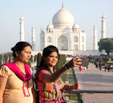 Geleneksel elbiseli genç kız Hindistan 'ın Agra şehrinde Taj Mahal' in önünde poz veriyor..