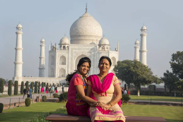 Indian mother and daughter in front of mughal monument Taj Mahal seven wonder of the world in Agra, India.