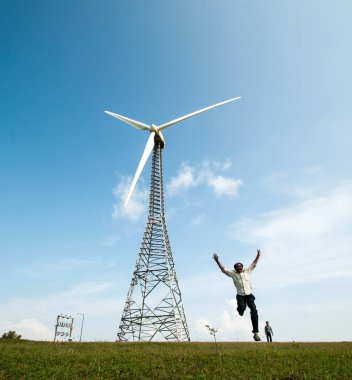  Turist tepe istasyonunda yel değirmeninin önünde eğleniyor..