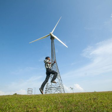  Turist tepe istasyonunda yel değirmeninin önünde eğleniyor..