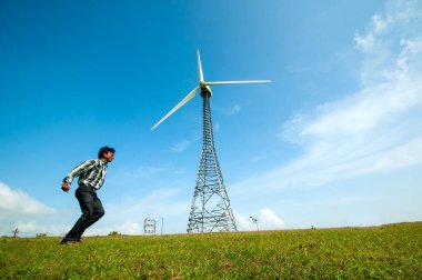  Turist tepe istasyonunda yel değirmeninin önünde eğleniyor..