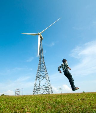 Turist tepe istasyonunda yel değirmeninin önünde eğleniyor..