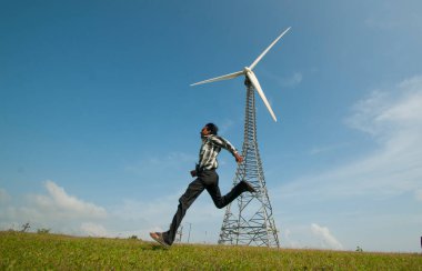  Turist tepe istasyonunda yel değirmeninin önünde eğleniyor..
