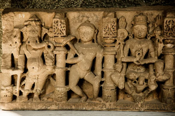 An ancient Indian sculpture of the Hindu god and goddess carved in stone.