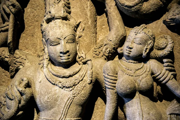 An ancient Indian sculpture of the Hindu god and goddess carved in stone.