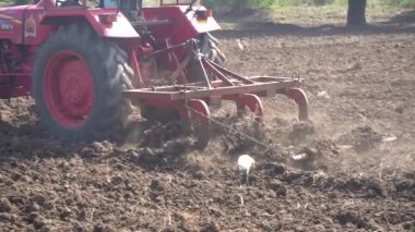 NASHIK, MAHARASHTRA, INDIA 8 HAZİRAN 2020: Kimliği belirsiz traktörlü çiftçi traktör ekimi için arazi hazırlıyor.