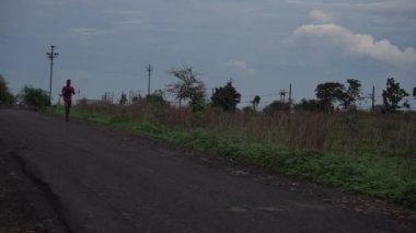 AMRAVATI, MAHARASHTRA, INDIA 27 HAZİRAN 2020: Kimliği belirsiz bir adam sabah ormanda koşuyor.