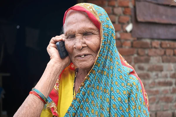 Indian senior rural woman using phone at village