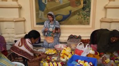 VRINDAVAN, INDIA - 11 Mart 2017: Vrndavana, Vrindavan 'daki Sri Krishna-Balaram ISKCON Tapınağında çelenk yapan tanımlanamayan dindar kadınlar kutsal bir yer olarak kabul ediliyor