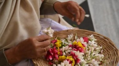 VRINDAVAN, INDIA - 11 Mart 2017: Vrndavana, Vrindavan 'daki Sri Krishna-Balaram ISKCON Tapınağında çelenk yapan tanımlanamayan dindar kadınlar kutsal bir yer olarak kabul ediliyor