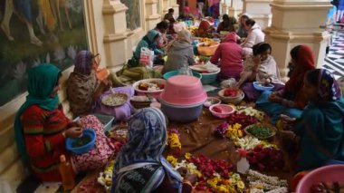 VRINDAVAN, INDIA - 11 Mart 2017: Vrndavana, Vrindavan 'daki Sri Krishna-Balaram ISKCON Tapınağında çelenk yapan tanımlanamayan dindar kadınlar kutsal bir yer olarak kabul ediliyor