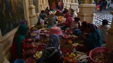 VRINDAVAN, INDIA - 11 Mart 2017: Vrndavana, Vrindavan 'daki Sri Krishna-Balaram ISKCON Tapınağında çelenk yapan tanımlanamayan dindar kadınlar kutsal bir yer olarak kabul ediliyor