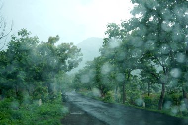 Yağmur soyut arka planda düşer, yağmurlu günlerde araba camlarına yağmur damlaları düşer