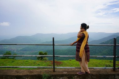Tepe istasyonuna bakan ve doğanın tadını çıkaran Hintli kadın..