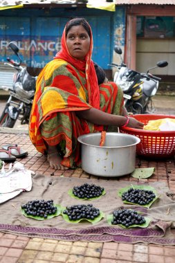 CHIKHALDARA, MAHARASHTRA, INDIA 29 HAZİRAN 2020: Köyün sokaklarında sabah taze meyve satan kabile kadını, Maharashtra kırsalında günlük yaşam tarzı.