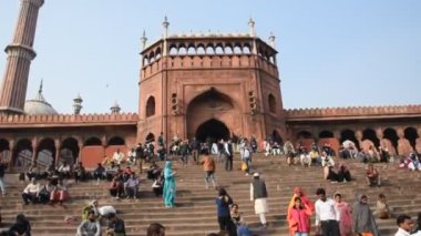 DELHI, Hindistan - 13 Şubat 2018: Jama Mescidi Camii merdivenlerinde birçok insan oturuyor, Jama Mescidi Delhi 'nin en ünlü simgelerinden biri..