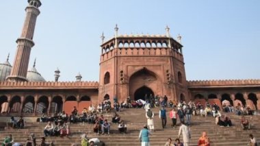 DELHI, Hindistan - 13 Şubat 2018: Jama Mescidi Camii merdivenlerinde birçok insan oturuyor, Jama Mescidi Delhi 'nin en ünlü simgelerinden biri..