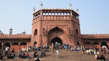 DELHI, Hindistan - 13 Şubat 2018: Jama Mescidi Camii merdivenlerinde birçok insan oturuyor, Jama Mescidi Delhi 'nin en ünlü simgelerinden biri..