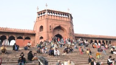 DELHI, Hindistan - 13 Şubat 2018: Jama Mescidi Camii merdivenlerinde birçok insan oturuyor, Jama Mescidi Delhi 'nin en ünlü simgelerinden biri..