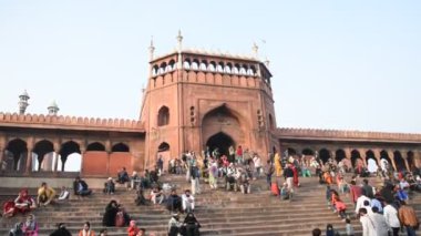 DELHI, Hindistan - 13 Şubat 2018: Jama Mescidi Camii merdivenlerinde birçok insan oturuyor, Jama Mescidi Delhi 'nin en ünlü simgelerinden biri..