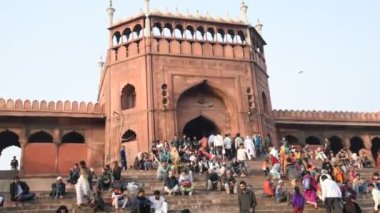 DELHI, Hindistan - 13 Şubat 2018: Jama Mescidi Camii merdivenlerinde birçok insan oturuyor, Jama Mescidi Delhi 'nin en ünlü simgelerinden biri..