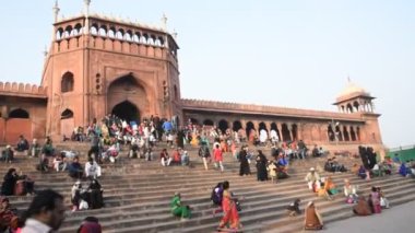 DELHI, Hindistan - 13 Şubat 2018: Jama Mescidi Camii merdivenlerinde birçok insan oturuyor, Jama Mescidi Delhi 'nin en ünlü simgelerinden biri..