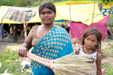 AMRAVATI, MAHARASHTRA, INDIA 2 Eylül 2020: Kulübesinin önündeki tanımlanamayan Hintli göçebe kadın insanlara satmak ve para kazanmak için geleneksel süpürge yapıyor.