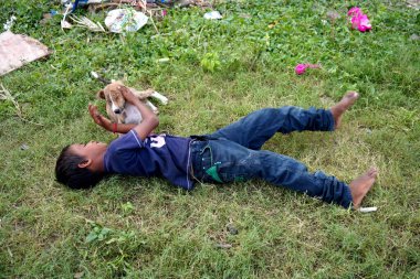 AMRAVATI, MAHARASHTRA, INDIA 2 Eylül 2020: Hintli kırsal çocuk sabah köyde köpek yavrusuyla oynuyor.
