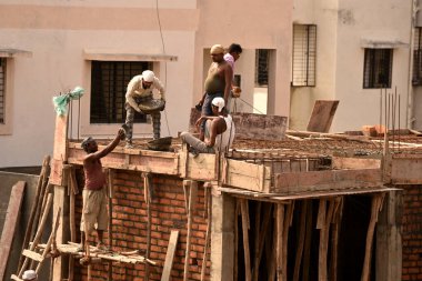 MUMBAI, MAHARASHTRA, INDIA 19 DECEMBER 2019 : Construction workers working on a building development site. In India building workers are not wear any safety measures at work.