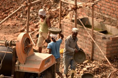 MUMBAI, MAHARASHTRA, INDIA 19 DECEMBER 2019 : Construction workers working on a building development site. In India building workers are not wear any safety measures at work.